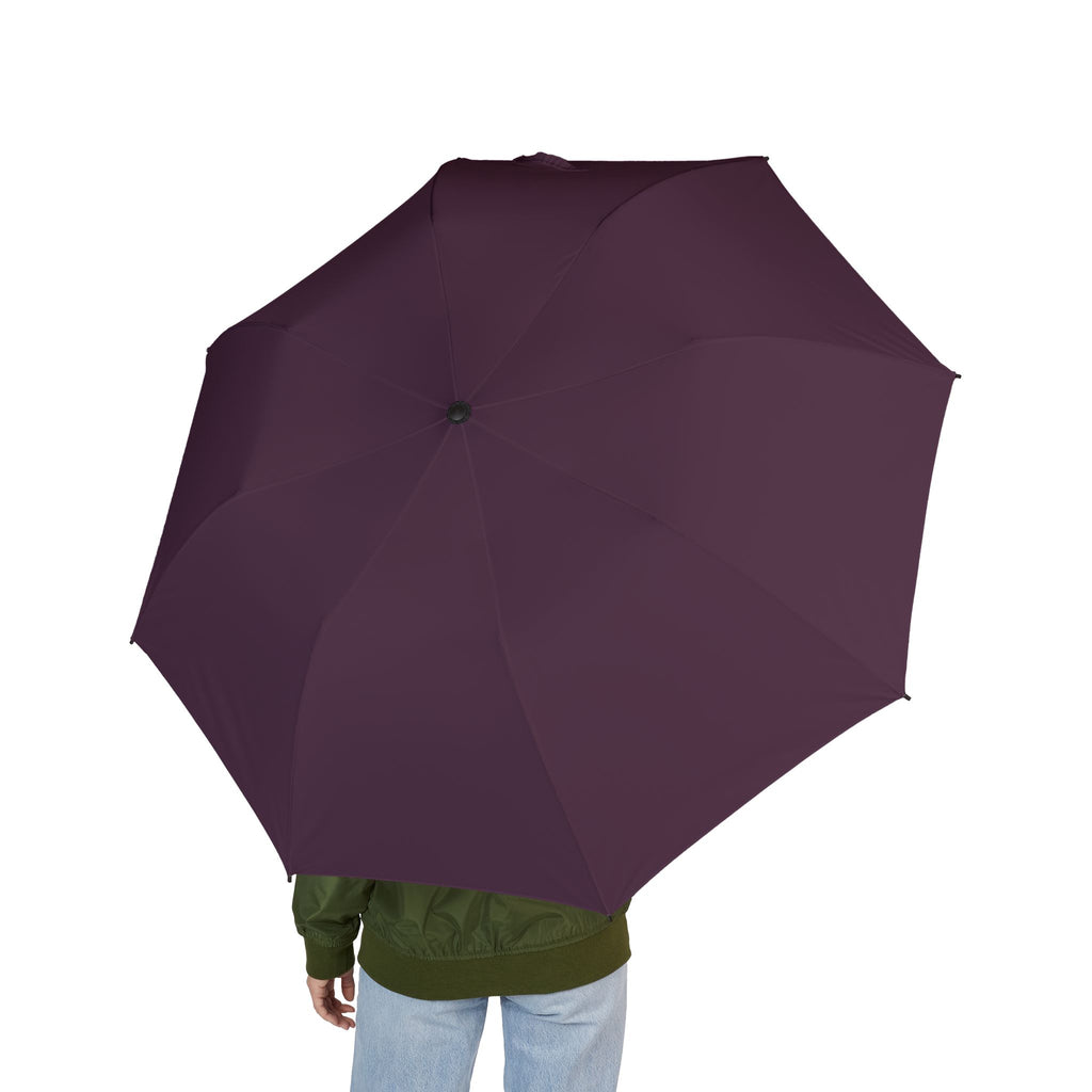 Person holding The Montefeltro plum folding umbrella, seen from behind