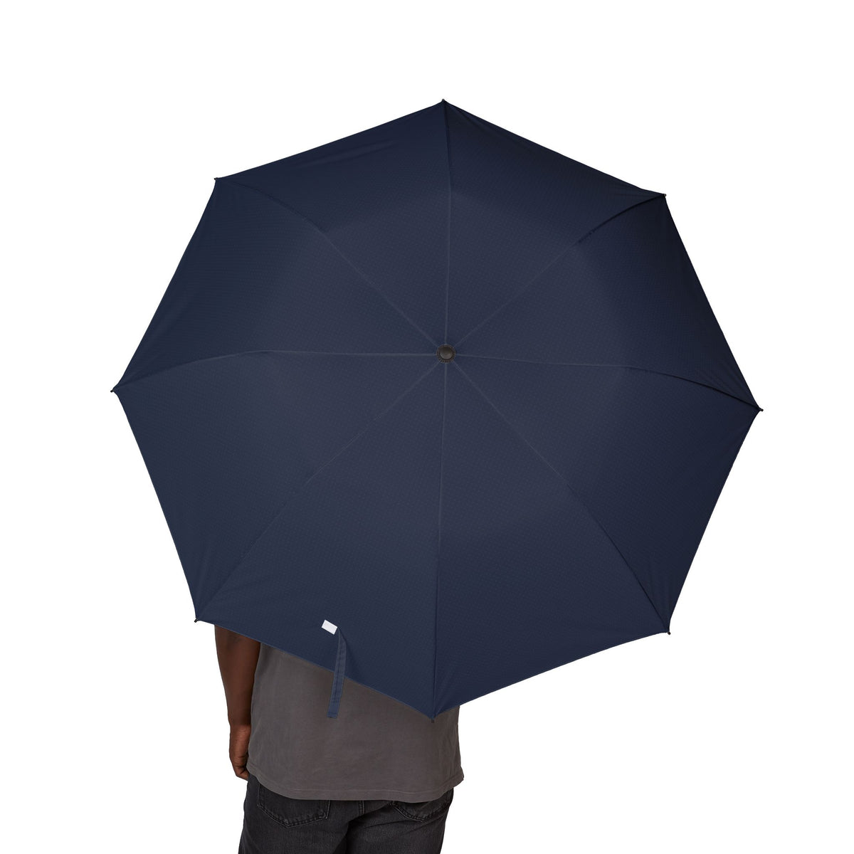 Person holding the Farnese navy tonal pin-dot folding umbrella, canopy from above
