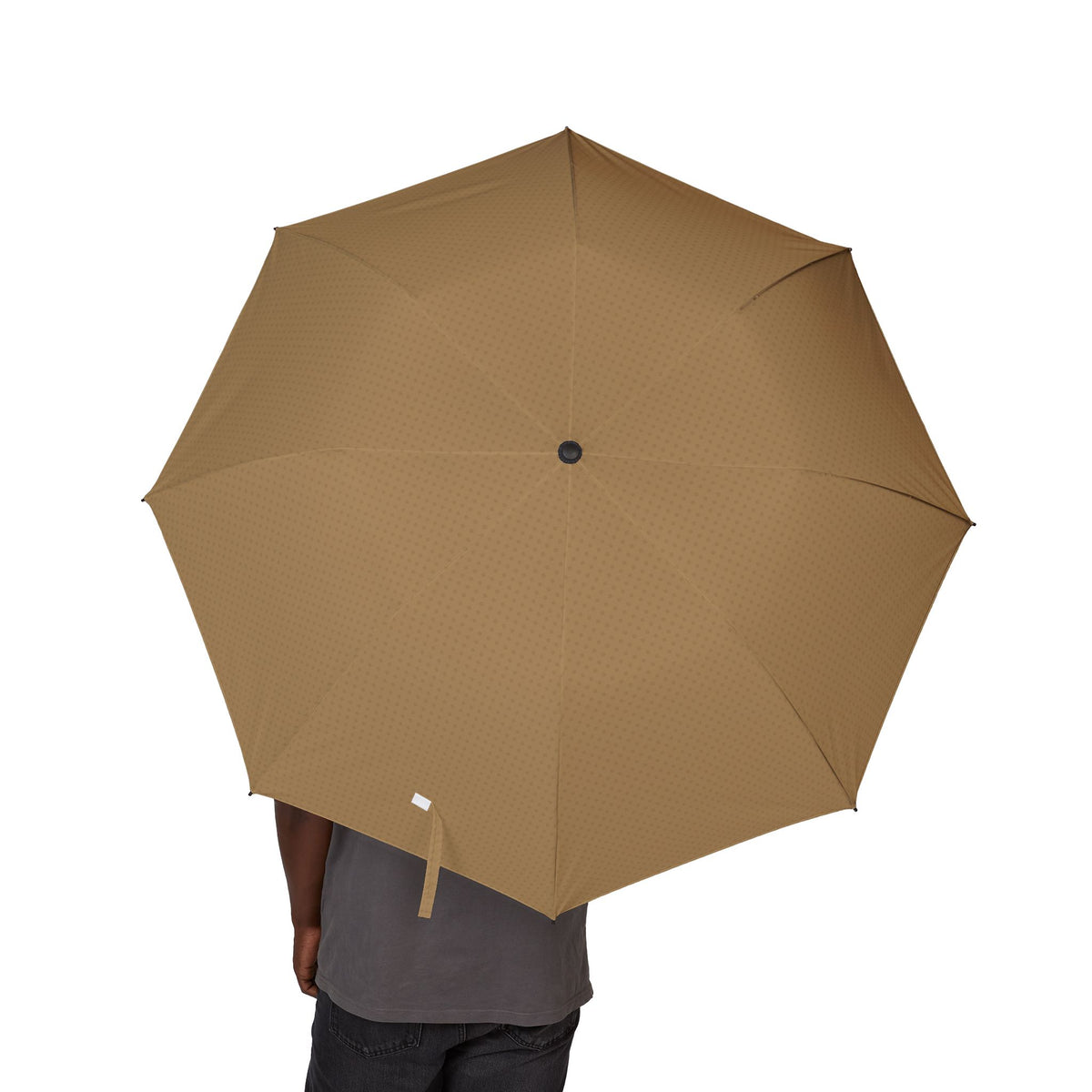 Person holding the Braganza camel tonal quatrefoil folding umbrella, canopy from above