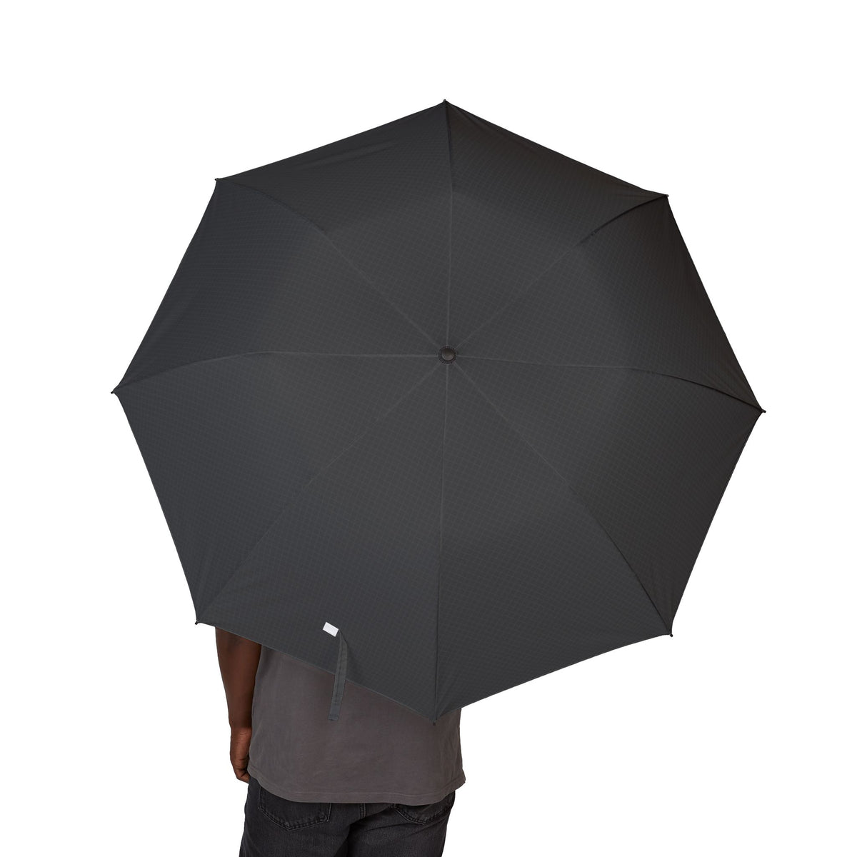 Person holding the Este charcoal tonal micro-check folding umbrella, canopy from above