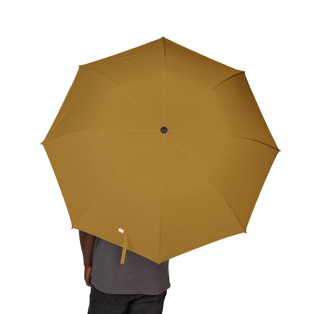 Person holding The Medina ochre folding umbrella, canopy from above