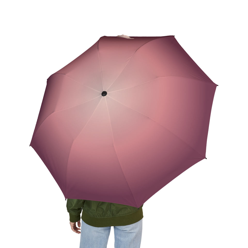 Person holding the Rothschild blush ombré folding umbrella, seen from behind
