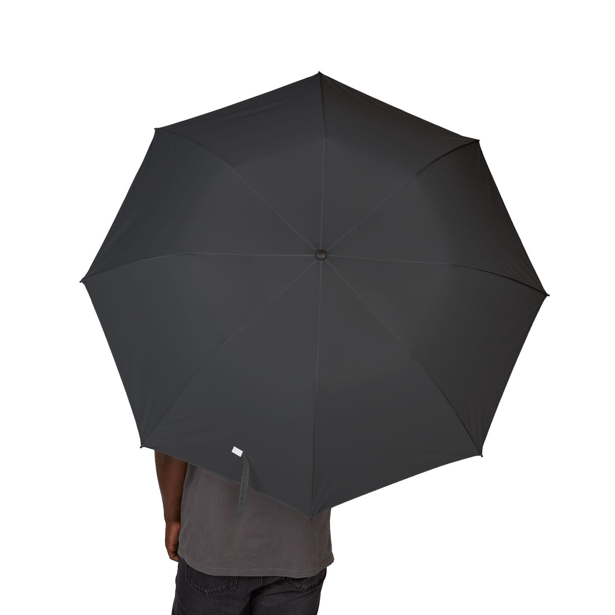Person holding The Beaufort charcoal folding umbrella, canopy from above
