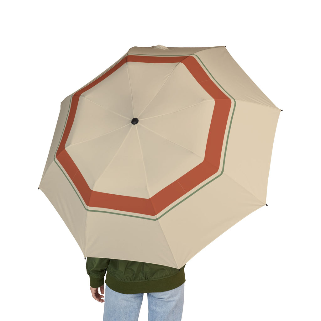 Person holding the Lascelles sand and terracotta folding umbrella, seen from behind