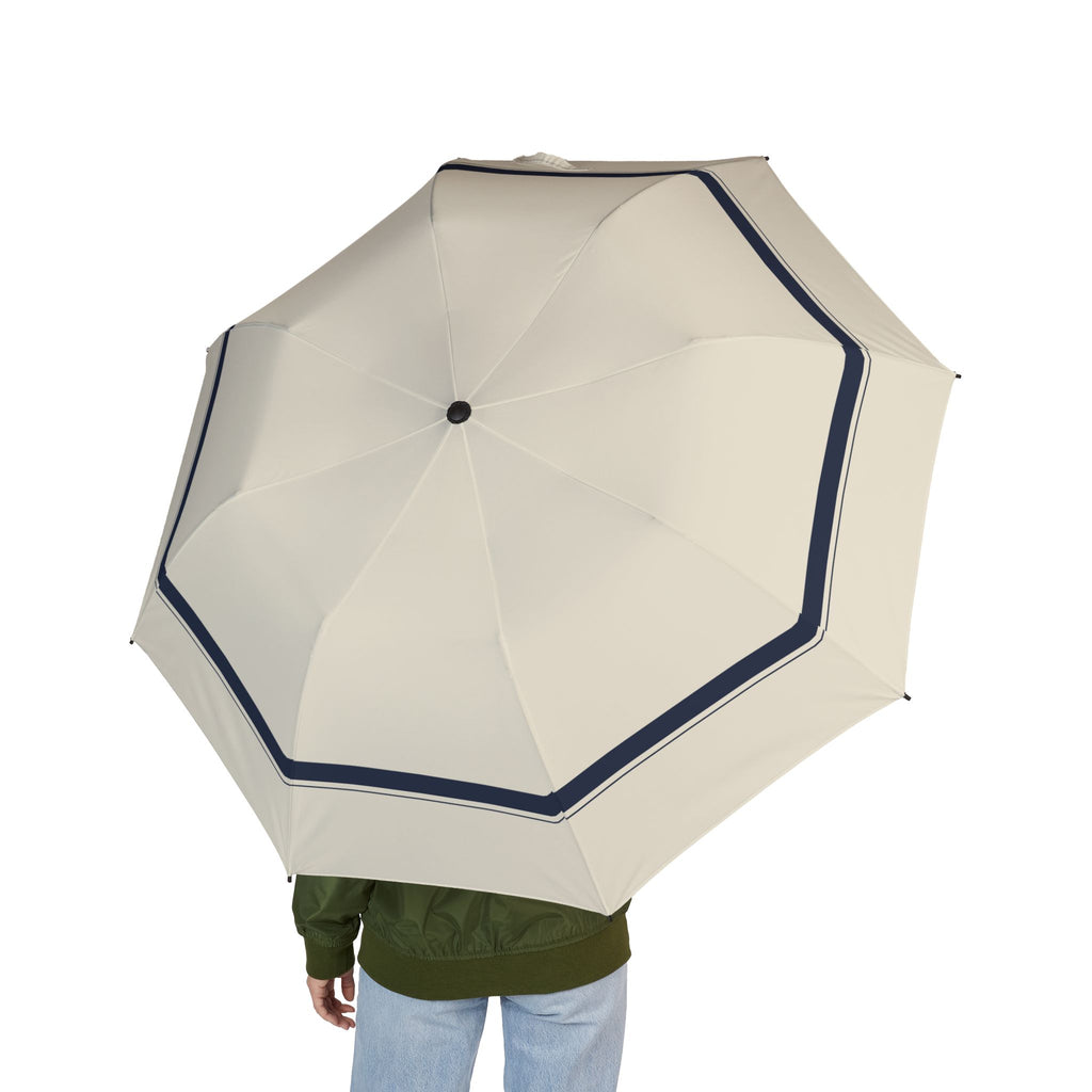 Person holding the Mowbray ivory navy-border folding umbrella, seen from behind