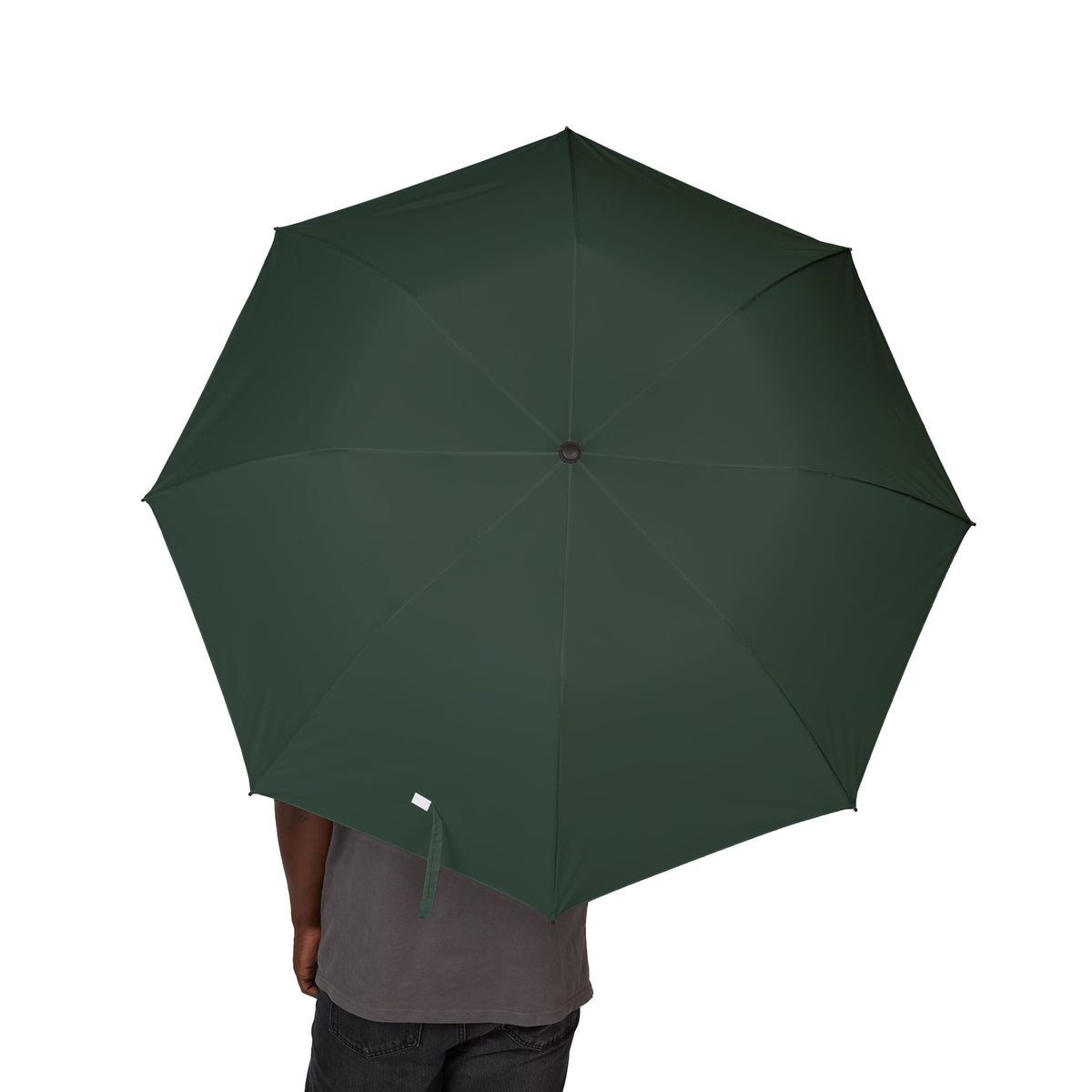 Person holding The Talbot bottle green folding umbrella, canopy from above