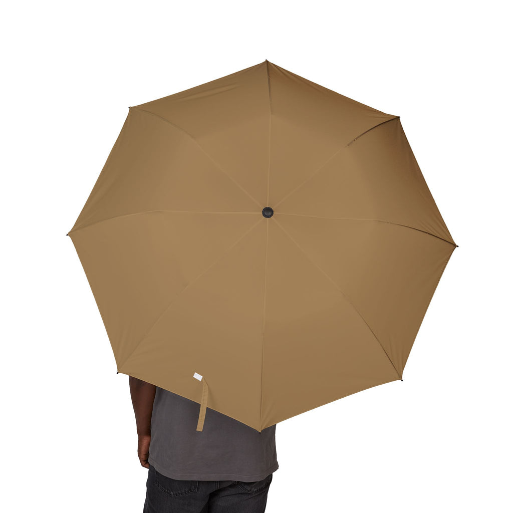 Person holding The Orsini camel folding umbrella, canopy from above