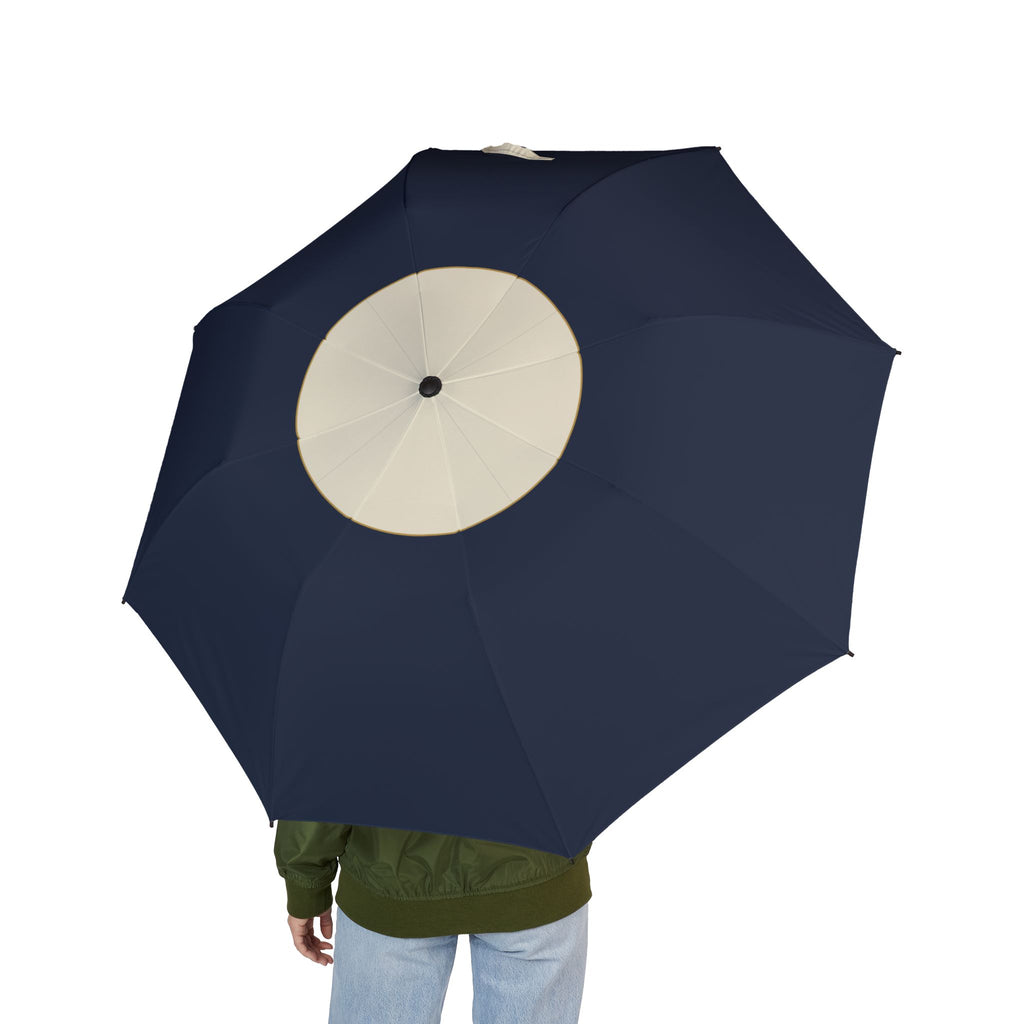 Person holding the Clifford cream crown folding umbrella, seen from behind