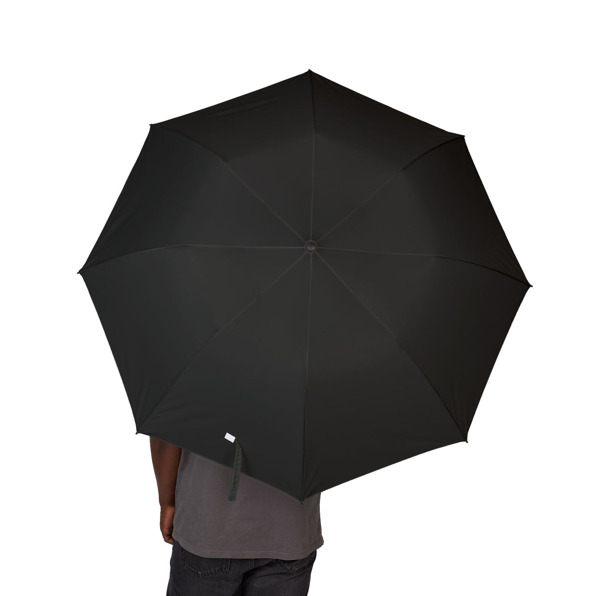 Person holding The Montmorency ink black folding umbrella, canopy from above
