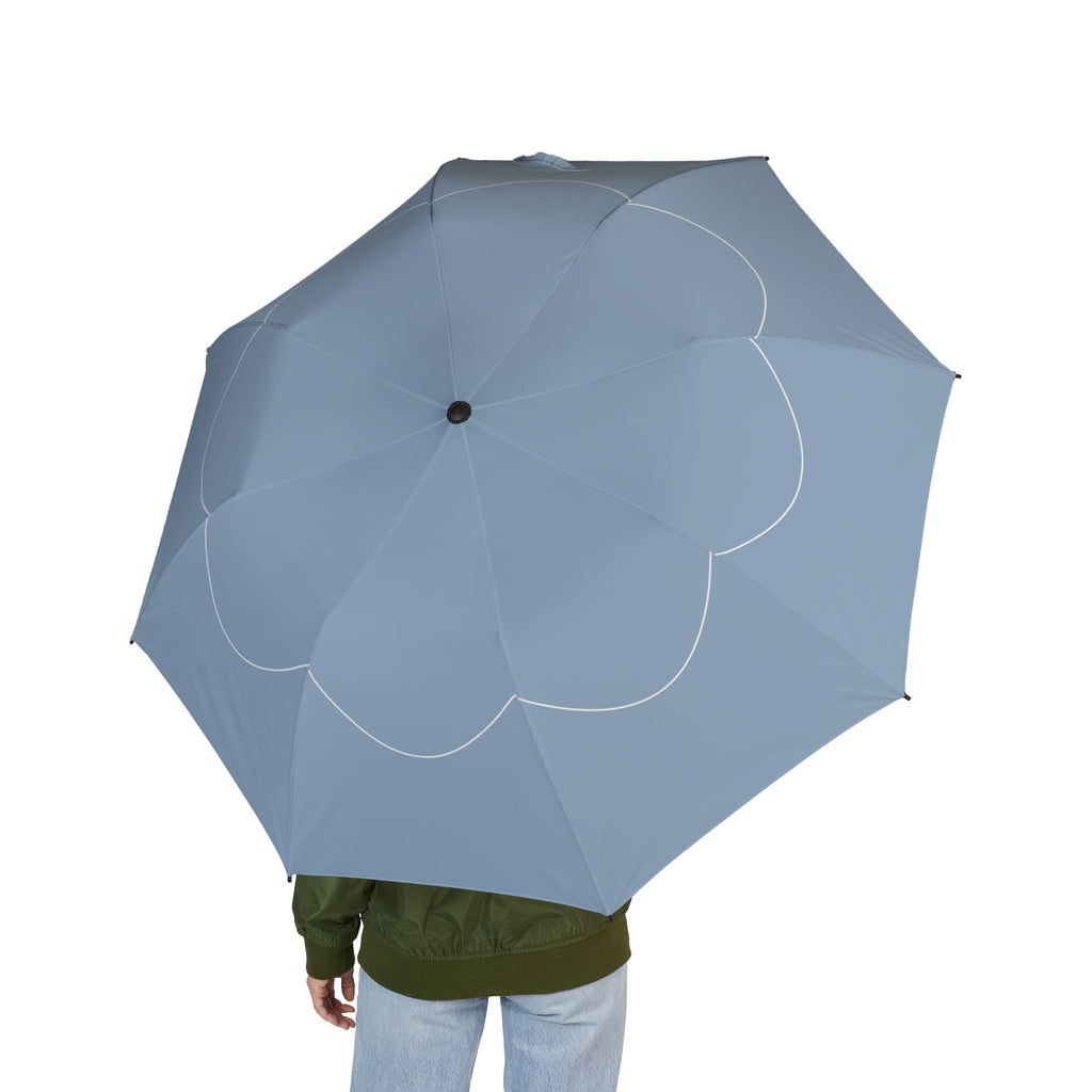 Person holding the Berkeley scallop line folding umbrella, seen from behind