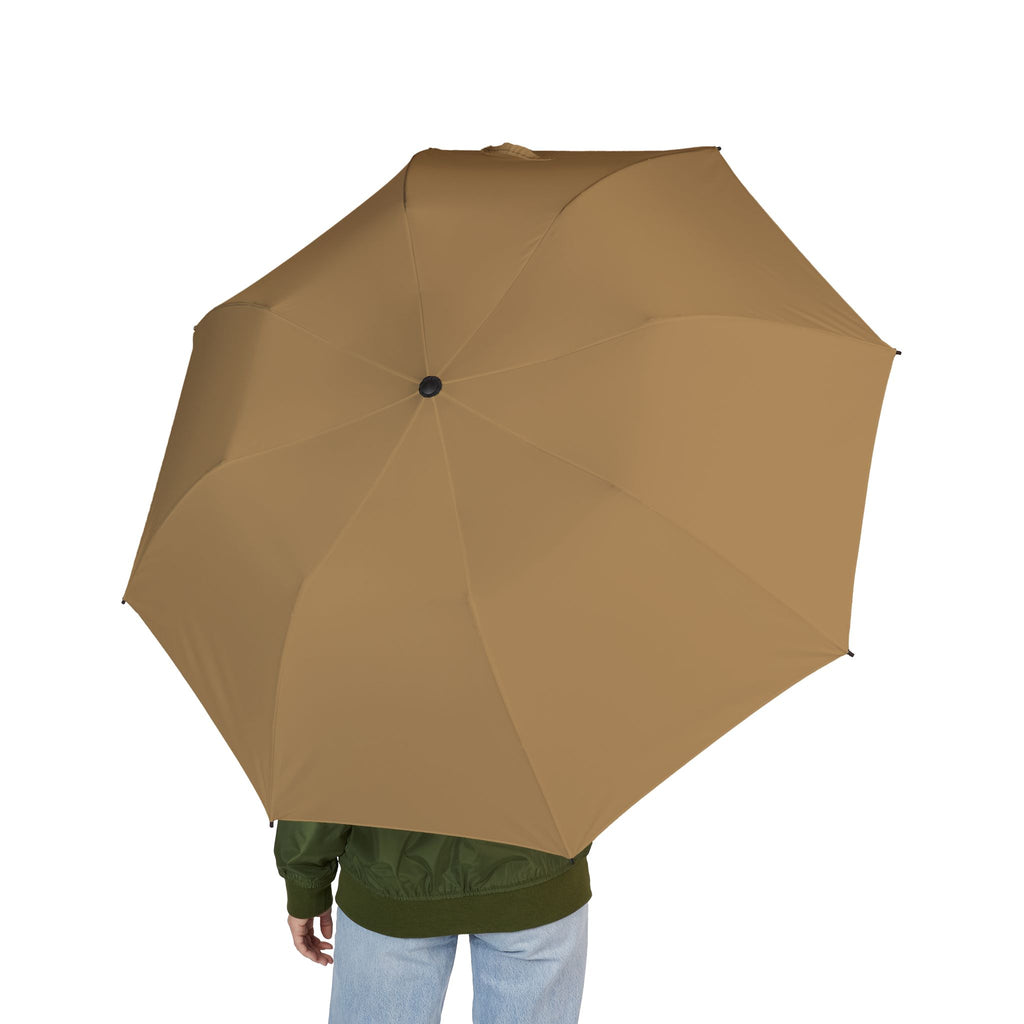 Person holding The Orsini camel folding umbrella, seen from behind
