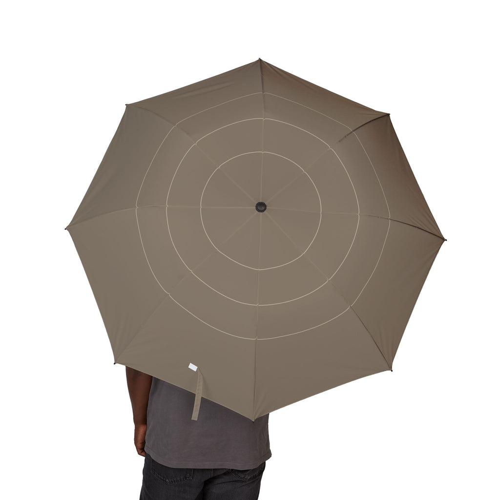 Person holding the Carew taupe ring folding umbrella, canopy from above