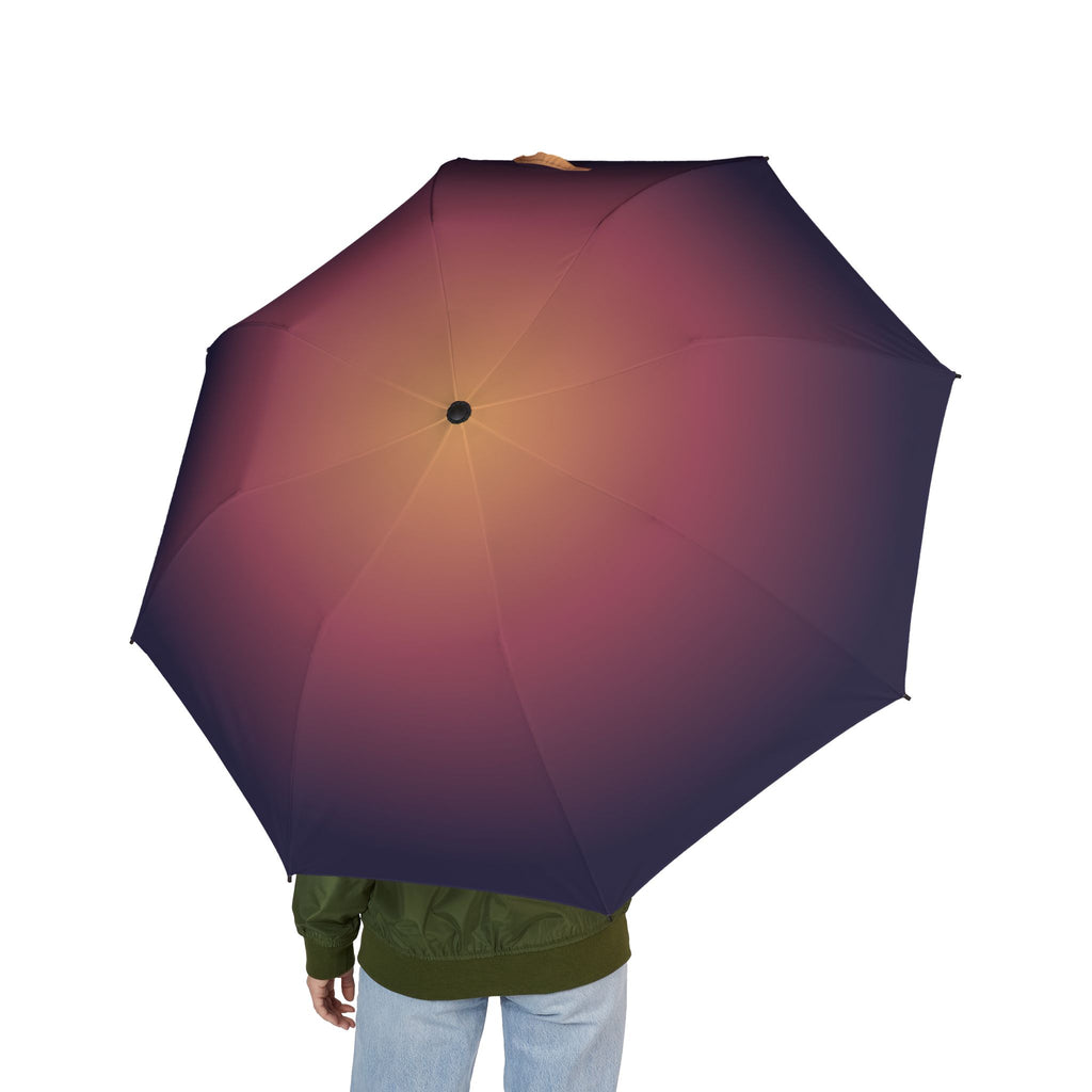 Person holding the Herbert dusk ombré folding umbrella, seen from behind