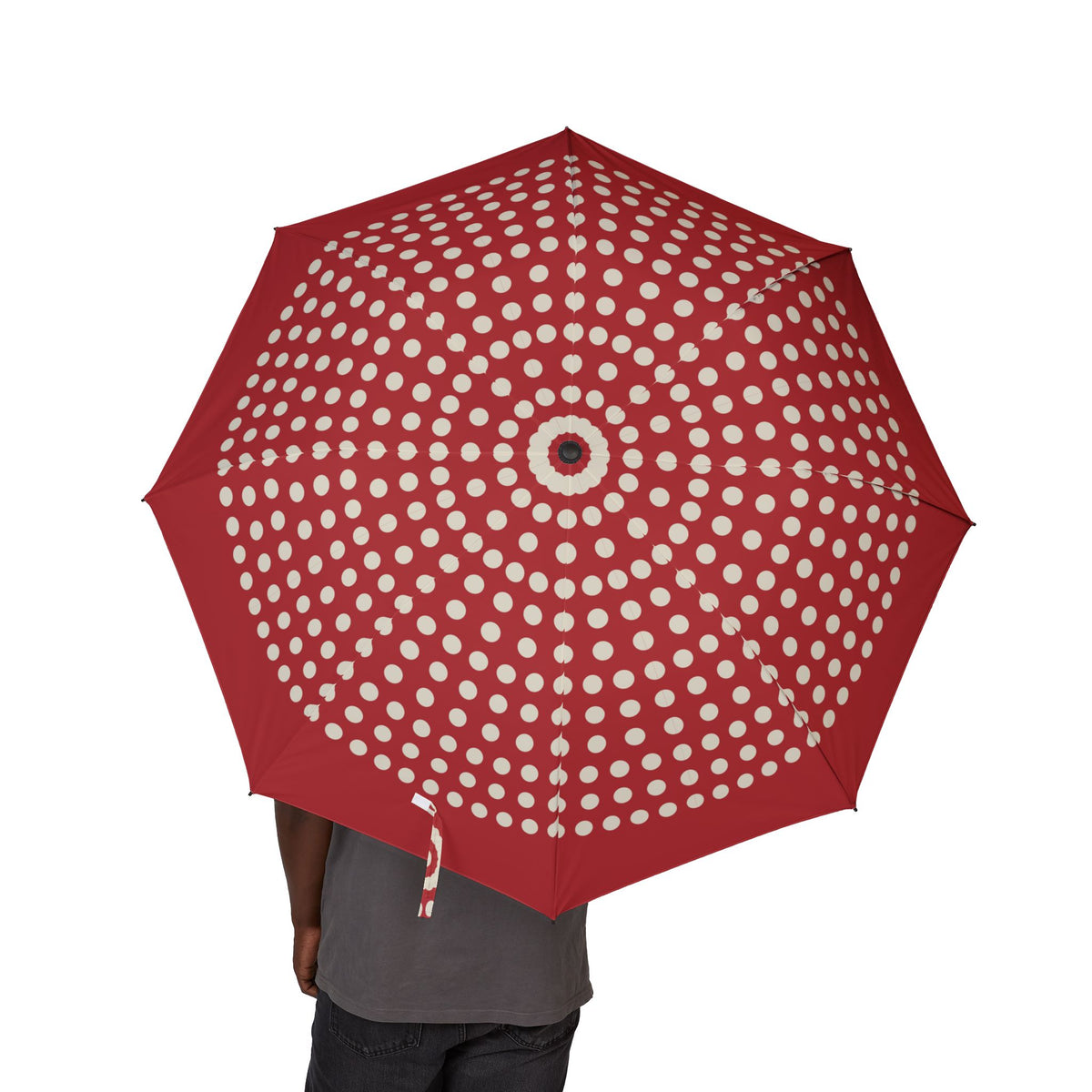 Person holding the Seymour red polka dot folding umbrella, canopy from above