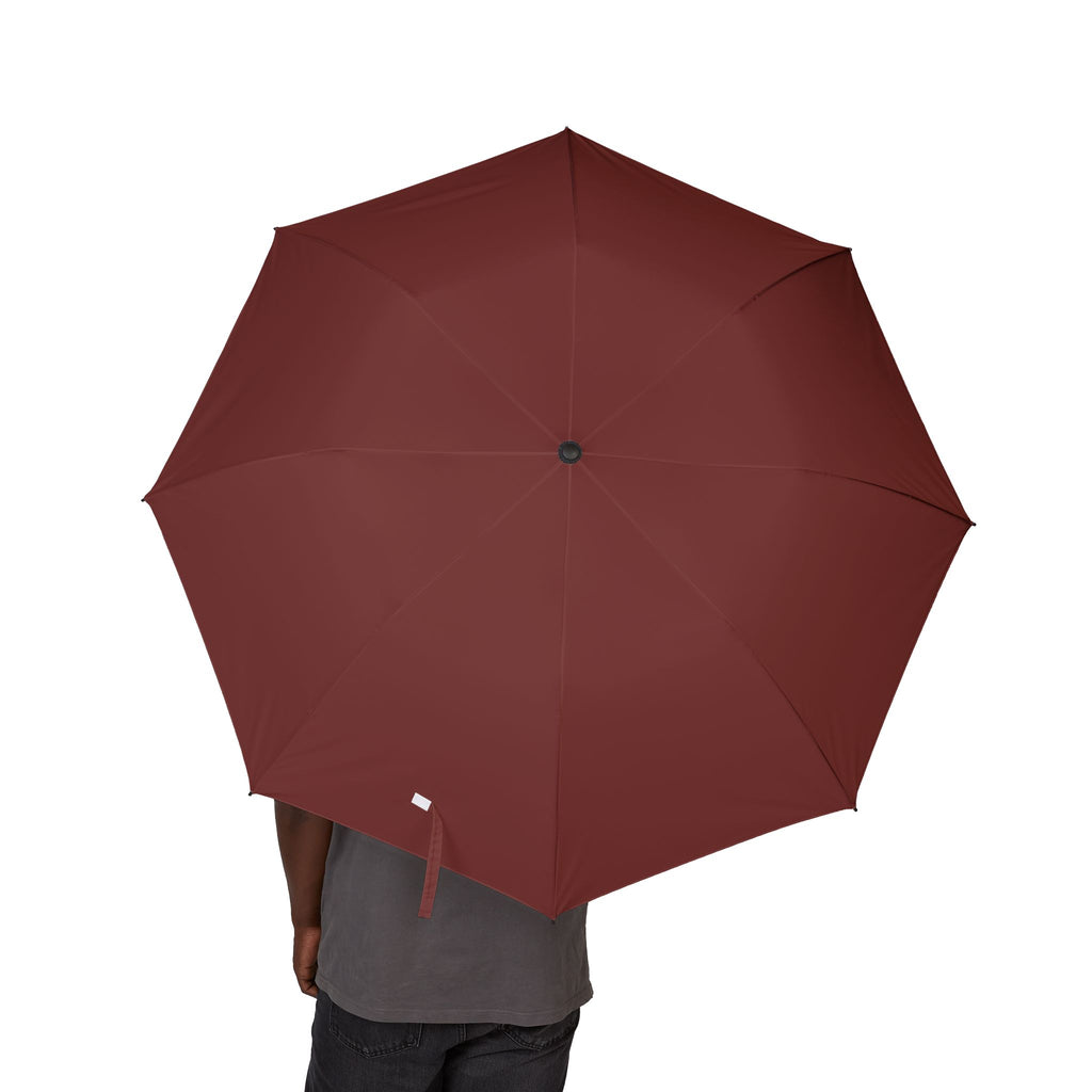 Person holding The Noailles oxblood folding umbrella, canopy from above