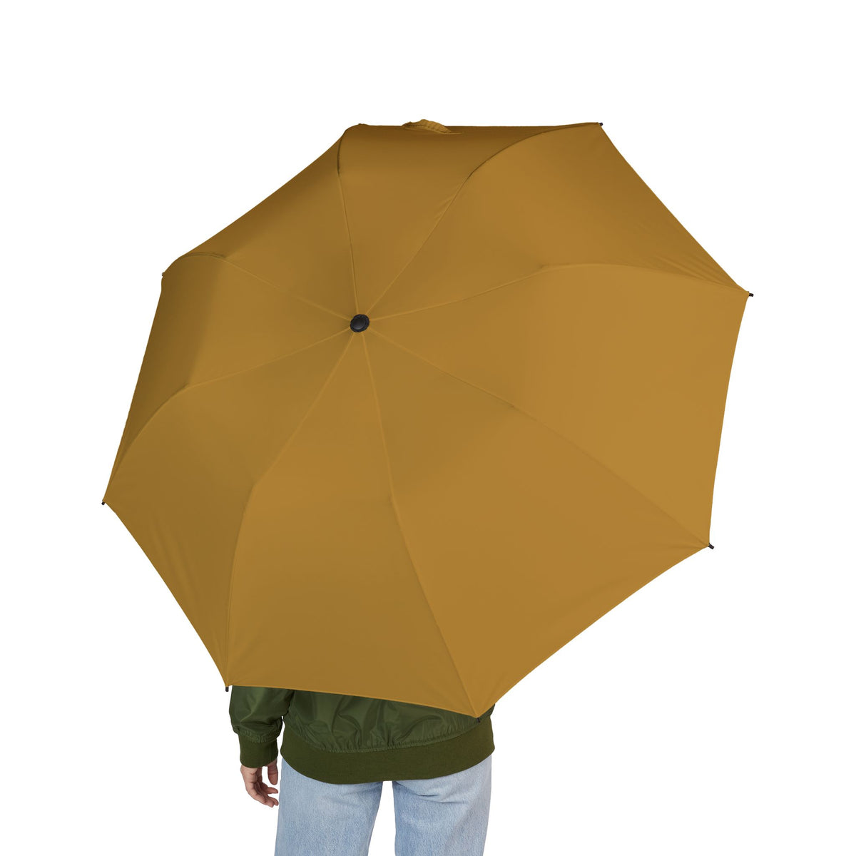 Person holding The Medina ochre folding umbrella, seen from behind